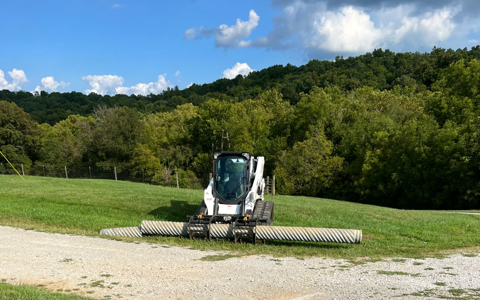 a skid steer holding a pole